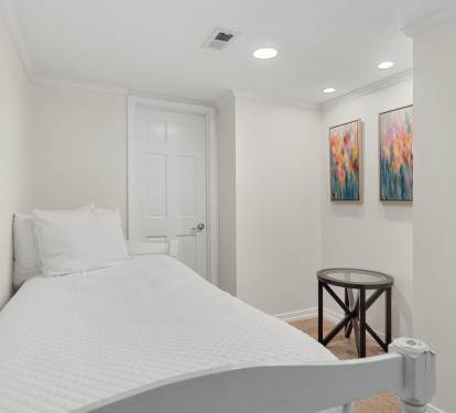 Rest peacefully in your cozy bedroom featuring crisp white linens, vibrant artwork, and thoughtful touches that make this space feel like home.