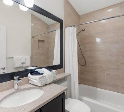 Step into your spotless bathroom featuring a soothing tub-shower combo, perfect for unwinding after exploring.