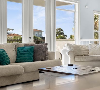 Sink into plush sofas where natural light floods your bright living space through floor-to-ceiling windows showcasing charming neighborhood views.