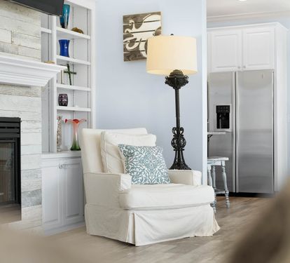 Curl up in your cozy reading chair beside the crackling fireplace, where coastal charm meets comfort in this beautifully designed living space.