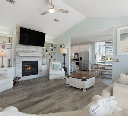 Unwind in your bright, open living space featuring a cozy fireplace, built-in shelving, and modern coastal touches that make you feel right at home.