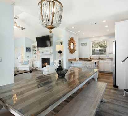 Gather around this stunning farmhouse dining table where memories are made beneath elegant crystal lighting.