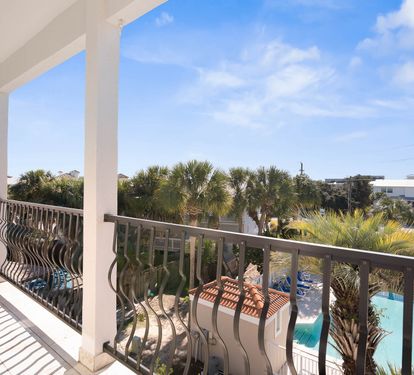 Relax on your private balcony overlooking tropical palms and the sparkling pool below on this perfect sunny day.