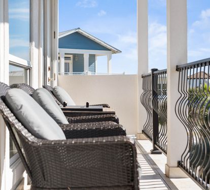 Step onto your private balcony where comfortable wicker loungers invite you to unwind while enjoying the beautiful coastal surroundings and fresh ocean breeze.