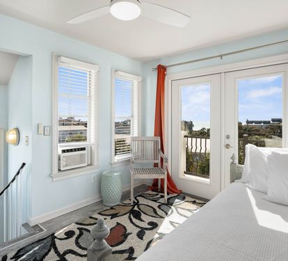 Wake up to stunning views from your bright bedroom with French doors opening to a private balcony overlooking the coastal landscape.