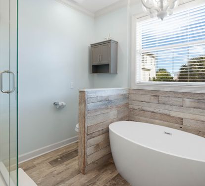 Soak in your elegant freestanding tub surrounded by rustic wood accents and natural light streaming through the window.