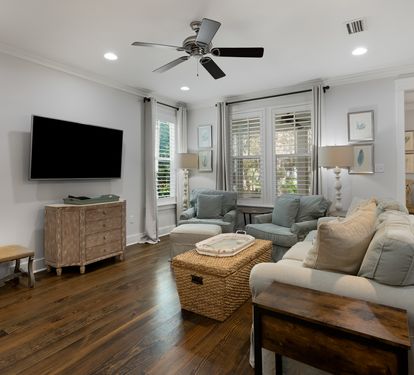 Sink into plush seating in your bright living room, where natural light floods through plantation shutters and a ceiling fan keeps you comfortable.