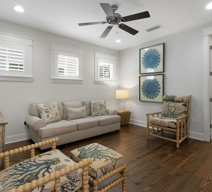 Relax in your bright coastal living room with comfortable seating, ceiling fan, and charming nautical touches throughout.