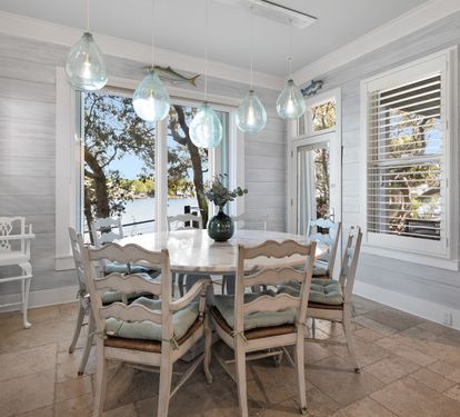 Gather around this charming dining table where coastal pendant lights cast a warm glow over your meals with stunning lake views.