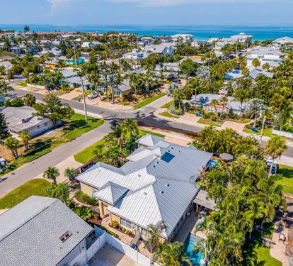 An aerial look at Coastal Cottage's Holmes Beach neighborhood, showing just how close the Gulf is — a short walk down tree-lined streets to the water.