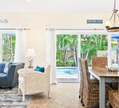 Comfortable seating and dining space open directly onto the private pool patio, blending indoor and outdoor living.