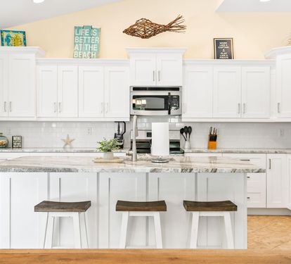 The 2025-renovated kitchen features white cabinetry, granite counters, and stainless steel appliances throughout.