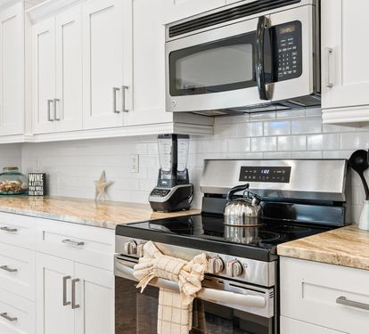 Granite counters and subway tile backsplash complete the fully renovated kitchen, stocked and ready for cooking.