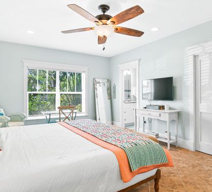The Master bedroom offers on suite bathroom, a flat-screen TV, ceiling fan, and bright, comfortable furnishings.