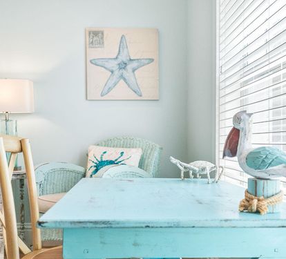 A weathered blue accent table and pelican decor bring playful coastal charm to the living space.