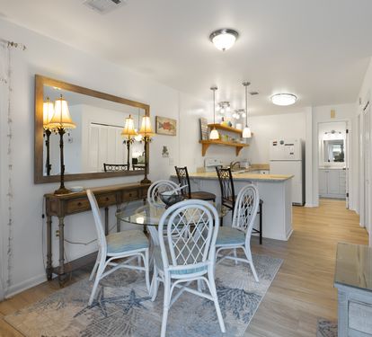 Step into your bright dining space where coastal charm meets comfort—perfect for sharing meals around the glass table.