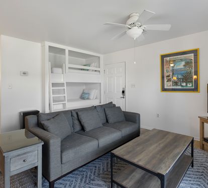 Your bright living room features a comfy sofa, entertainment center, and built-in bunk beds for extra guests.