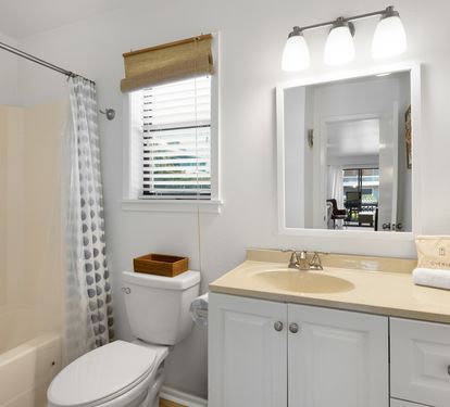 Unwind in your private bathroom featuring a spacious tub, well-lit vanity, and fresh towels awaiting your arrival.