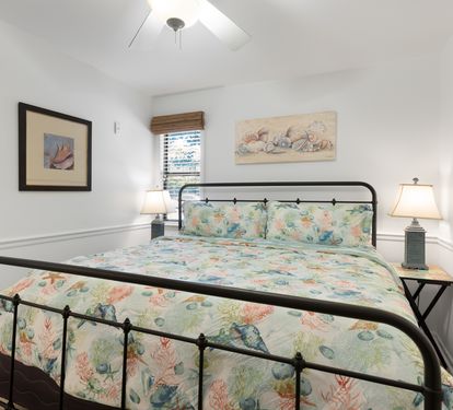 Drift off to sleep on your cozy bed surrounded by beautiful ocean-themed artwork and gentle coastal colors that create a serene retreat.