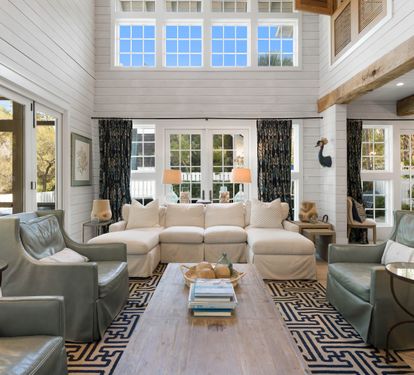 Unwind in this stunning living room where soaring ceilings, exposed beams, and soft natural light create your perfect retreat.