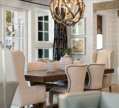 Gather around this elegant dining table where memorable meals await beneath warm lighting.