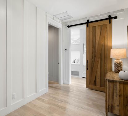 Step into your stylish hallway where rustic barn doors and coastal furnishings create a warm welcome to your peaceful retreat.
