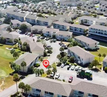 Aerial view of the vacation rental property nestled within a well-maintained residential community with landscaped grounds and convenient parking.