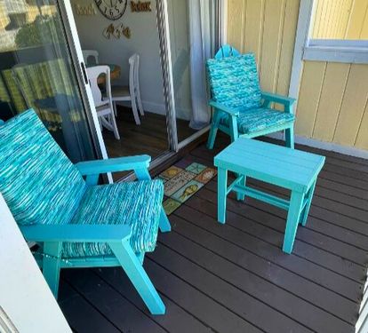 Unwind on your private deck with cheerful turquoise seating, where morning coffee and evening sunsets become your daily ritual.
