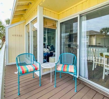 Your private deck awaits with colorful seating where you can sip morning coffee while watching palm trees sway in the coastal breeze.