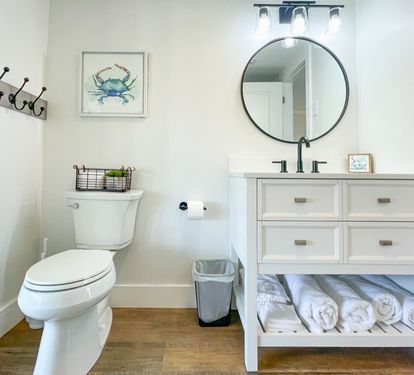 Step into your bright, coastal-themed bathroom with thoughtful touches like fresh towels and charming nautical decor waiting for you.