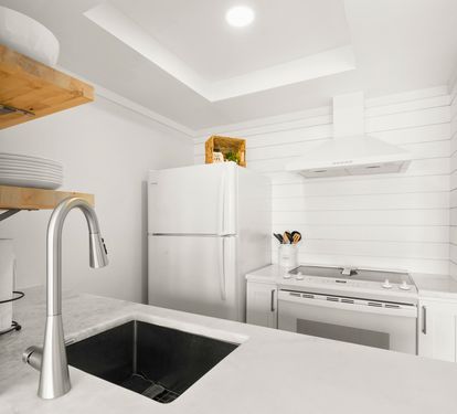 Your bright kitchen features sleek counters, modern appliances, and open shelving for easy meal prep during your stay.