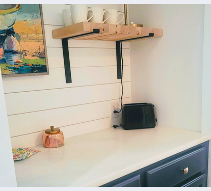 Your charming kitchenette corner features fresh white shiplap walls, a sleek toaster for morning treats, and coffee mugs ready for your perfect brew.
