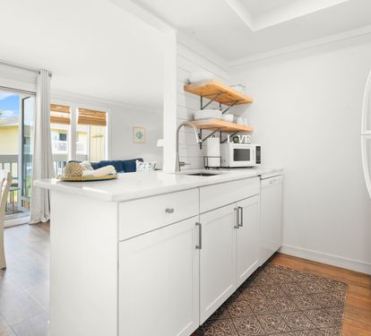 Step into your bright, modern kitchen featuring crisp white cabinets, open shelving, and everything you need to create memorable meals.