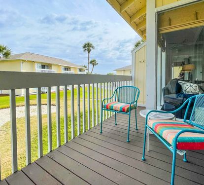 Step onto your private balcony with cheerful turquoise seating and colorful cushions, perfect for morning coffee or evening relaxation.