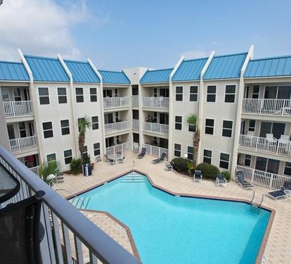 Your balcony view overlooking a sparkling courtyard pool—your perfect spot for morning coffee or sunset unwinding.
