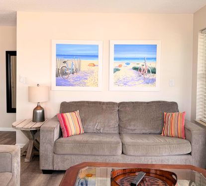 Settle into your cozy living space with plush seating and cheerful beach-inspired art that brings the ocean to you. The bright, airy room invites you to unwind after a day of exploring.
