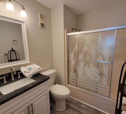 Primary bathroom with a full tub/shower combo—perfect for relaxing after a day at the beach.