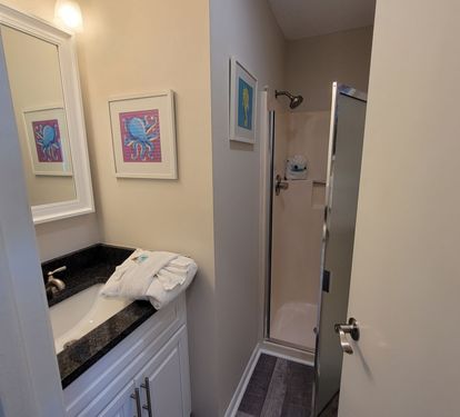 Clean guest bathroom with walk-in shower and plenty of space to refresh after a beach day.