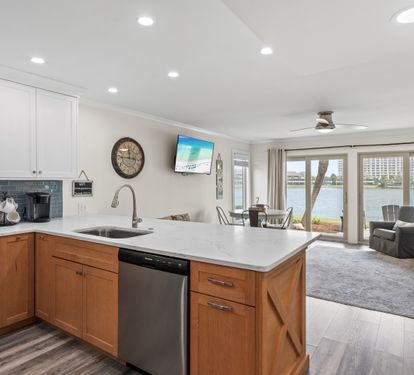 Your spacious waterfront retreat features a sleek modern kitchen flowing into a comfortable living area with stunning lake views right outside your door.