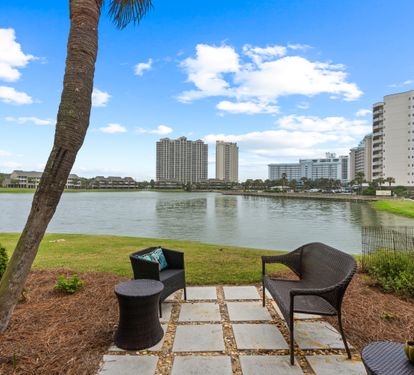 Unwind in your private lakeside oasis with stunning water views and comfortable seating under swaying palms.