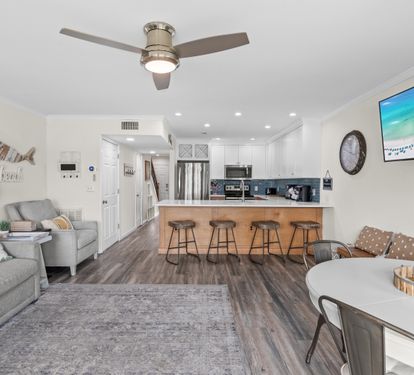 Relax in your open-concept haven with coastal décor, modern kitchen island seating, and cozy living space perfect for gathering.