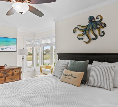Unwind in your coastal-themed bedroom with ocean views, ceiling fan comfort, and charming nautical décor creating the perfect seaside retreat.