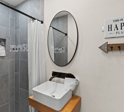 Refresh in your stylish bathroom featuring a modern vessel sink, spacious walk-in shower, and cheerful decor that makes every morning bright.