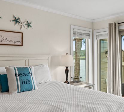 Wake up to stunning waterfront views from your cozy bedroom, where coastal charm meets comfort with thoughtful beach-themed touches.
