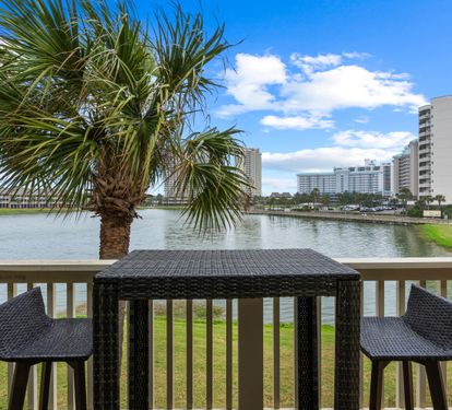 Sip your morning coffee at this waterfront bistro table, where peaceful lake views and swaying palms create the perfect backdrop for relaxation.