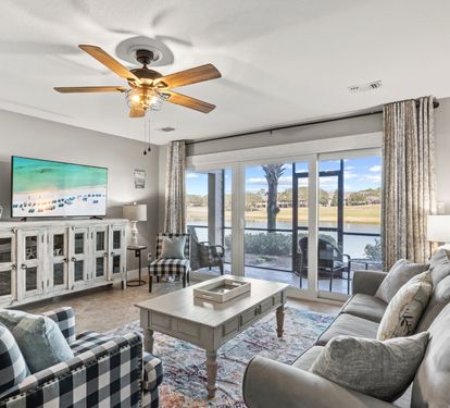 Bright, beautifully furnished living area with scenic lake views and direct patio access—perfect for relaxing coastal mornings and sunsets.