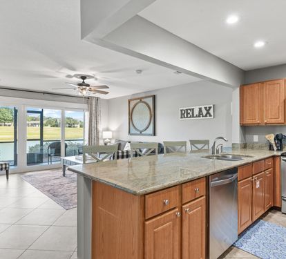Spacious open-concept kitchen and living area with granite counters and patio access—perfect for gathering and relaxing.