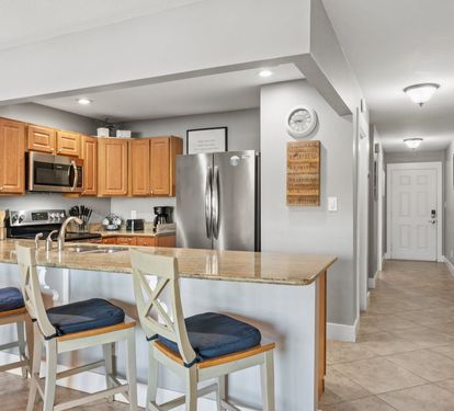 Spacious kitchen with stainless appliances, granite countertops, and bar seating—perfect for meals, snacks, and gathering together.