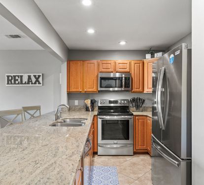 Modern kitchen with granite countertops, stainless appliances, and plenty of space for preparing family meals.