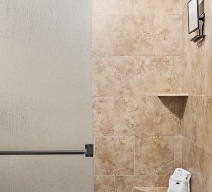 Walk-in tiled shower with updated finishes—perfect for rinsing off after a beach day.